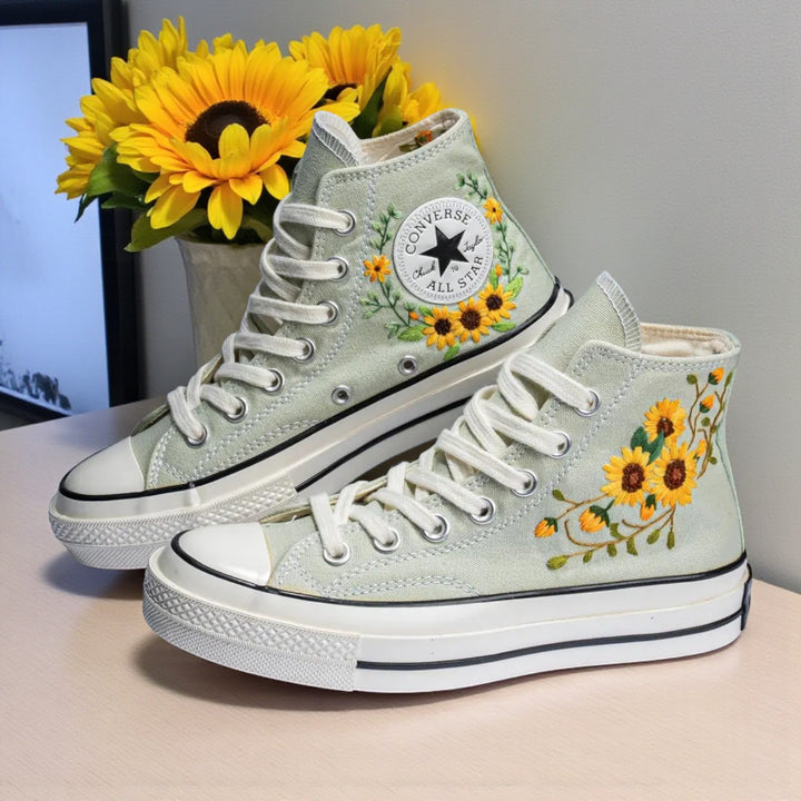 Sunflower Converse high-top shoes with embroidered floral design on a light green background