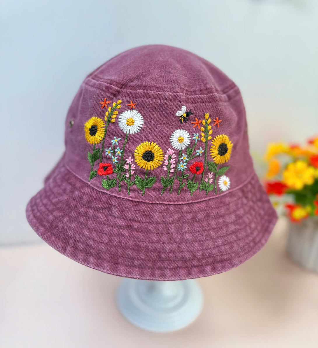 Stitchery Zone Sunflower Hand Embroidered Bucket Hat in purple with colorful floral embroidery and bee detail