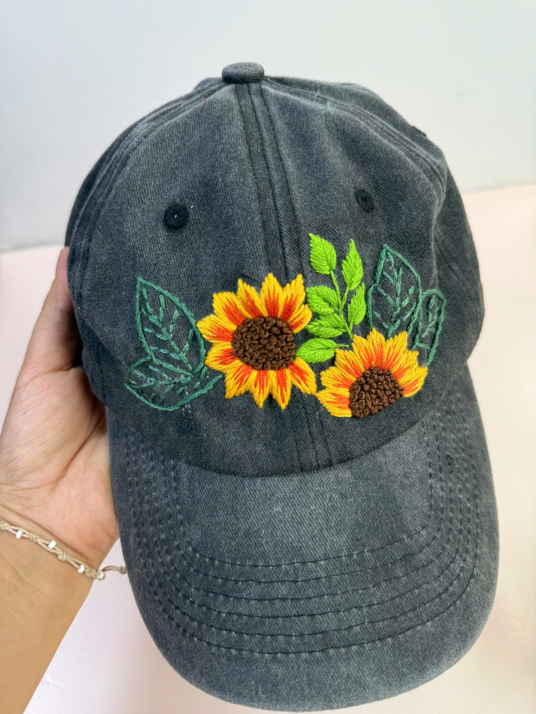 Sunflower Personalised Embroidered Hat in dark fabric with bright yellow sunflower and green leaf embroidery