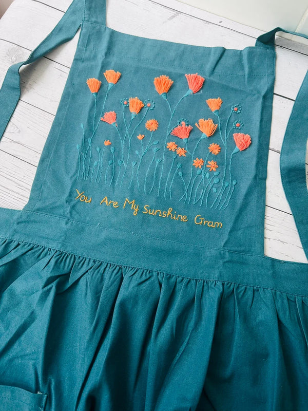 Floral Embroidered Apron For Women in teal with orange flower designs and You Are My Sunshine Gram text