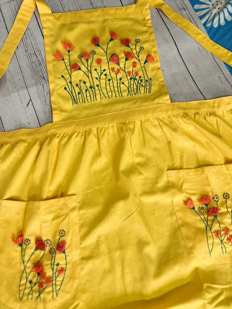 Yellow floral embroidered apron for women with orange and green flower designs by Stitchery Zone