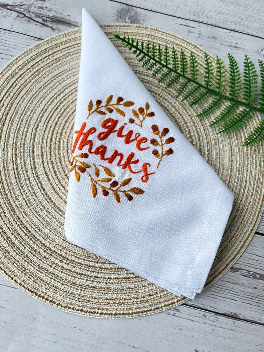 Thanksgiving Hand Embroidered Linen Napkin with Give Thanks design on woven placemat