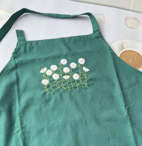 Green hand embroidered kitchen apron with white daisy floral design by Stitchery Zone