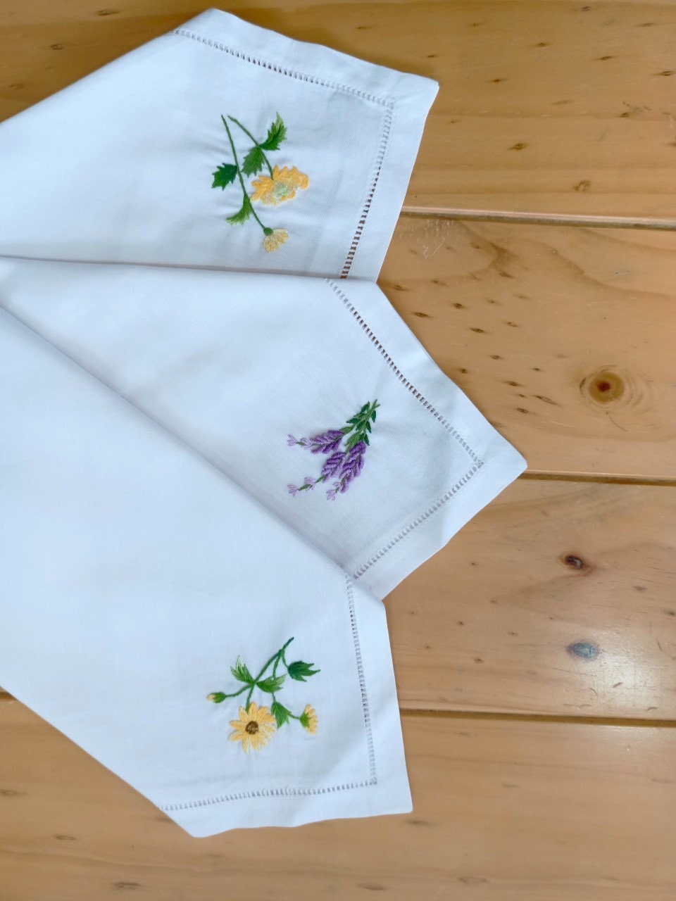 Stitchery Zone Wildflower Linen Dinner Napkins with embroidered yellow and purple floral designs on white fabric